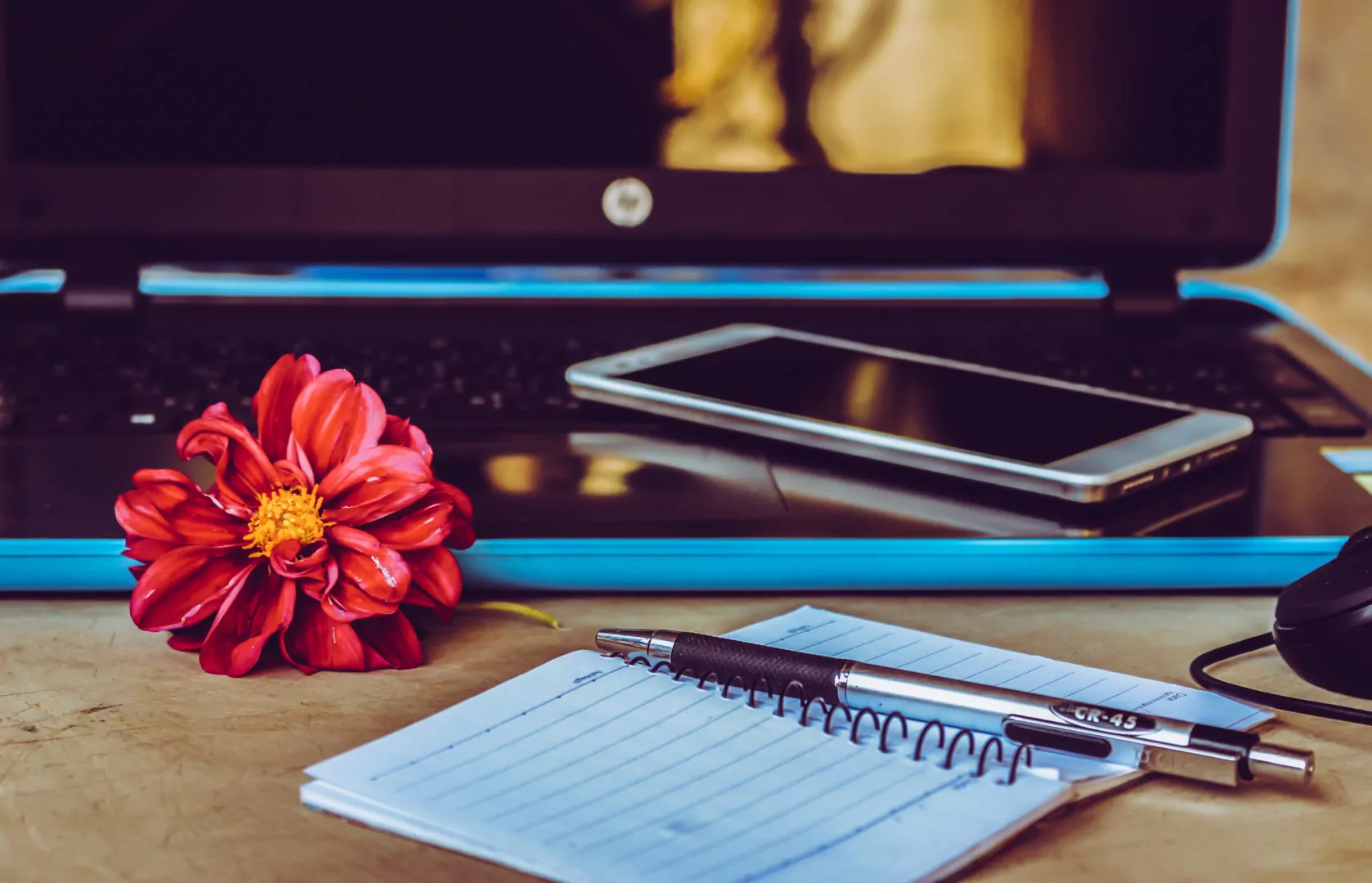 Canva - White Smartphone on Black Laptop Next to Pen on White Notepad