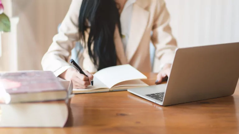 Cropped shot of businesswoman working on her project while writing the idea on notebook